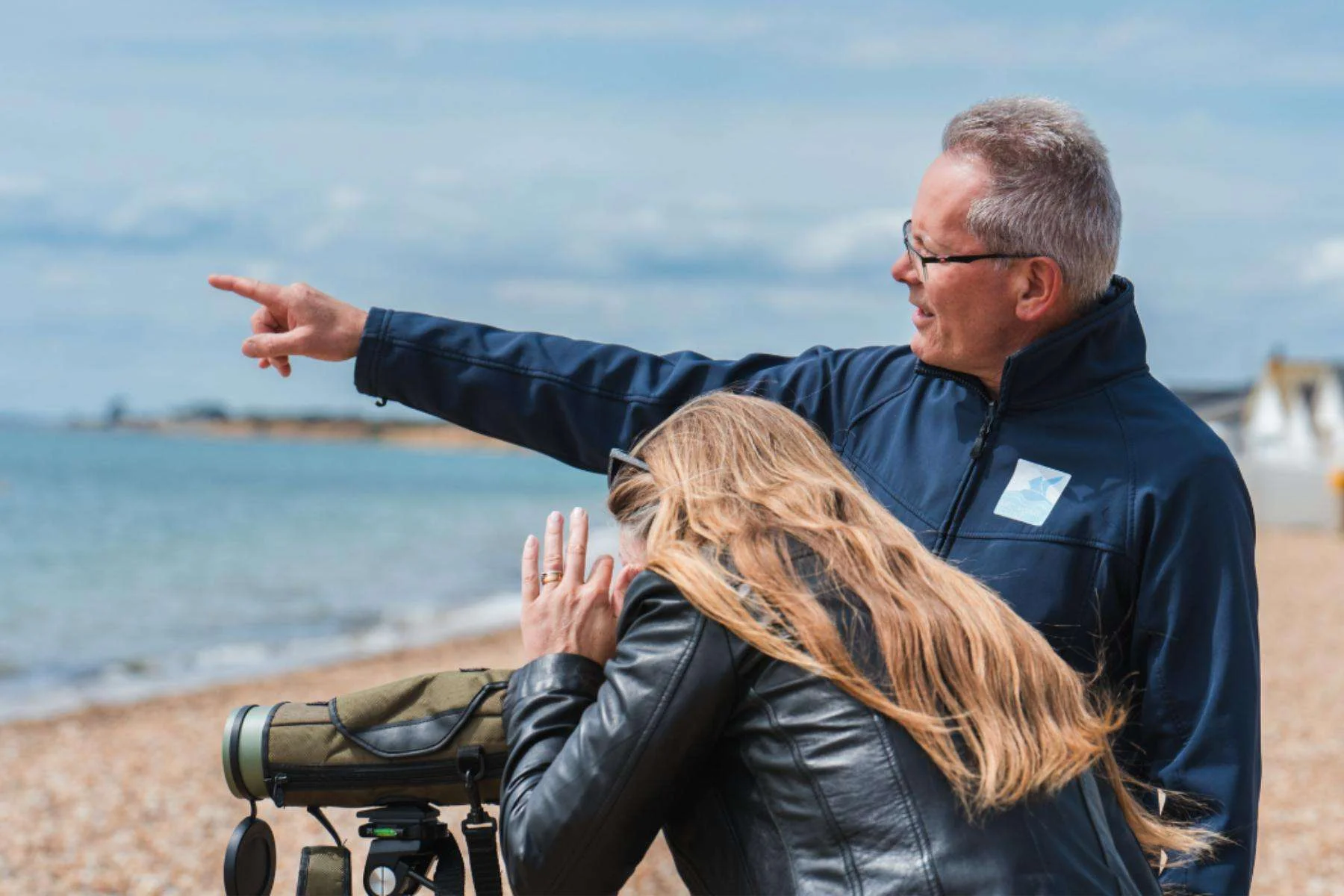 A Bird Aware ranger points out birds along the coast.